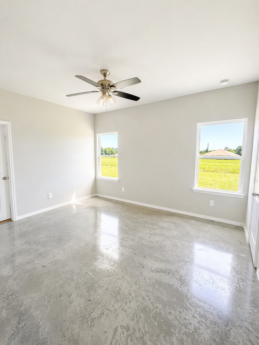 6 Greenway Drive Trinity, TX 75862 - Photo 11 of 27 an empty room with windows and chandelier fan