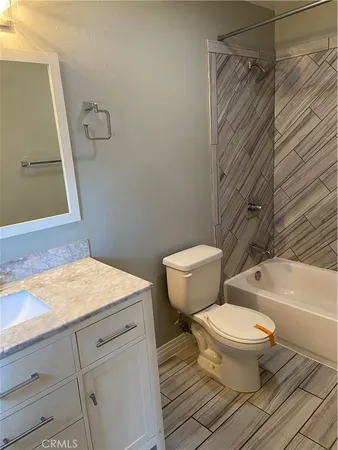 a bathroom with a granite countertop toilet sink and a bathtub
