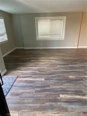 a view of a room with wooden floor and window
