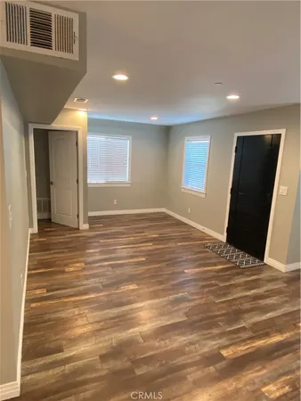 a view of a livingroom with wooden floor and a ceiling fan