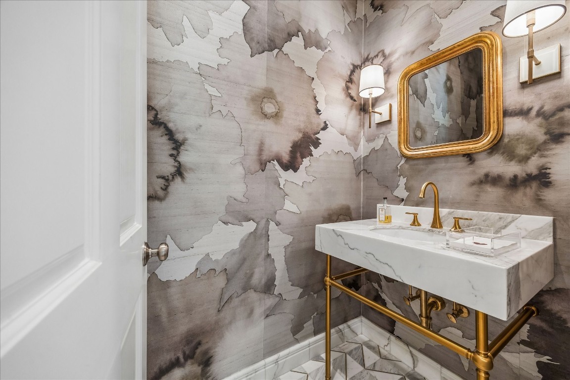 620 Hedwig Road Hunters Creek Village, TX 77024 - Photo 13 of 47 A sophisticated powder room featuring a marble console sink, Phillip Jeffries wallpaper, and warm brass fixtures.