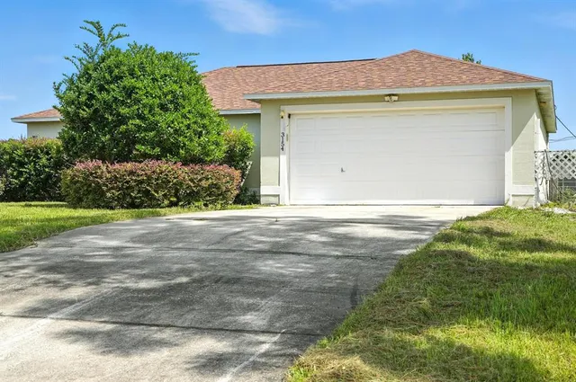 a front view of a house with yard and green space