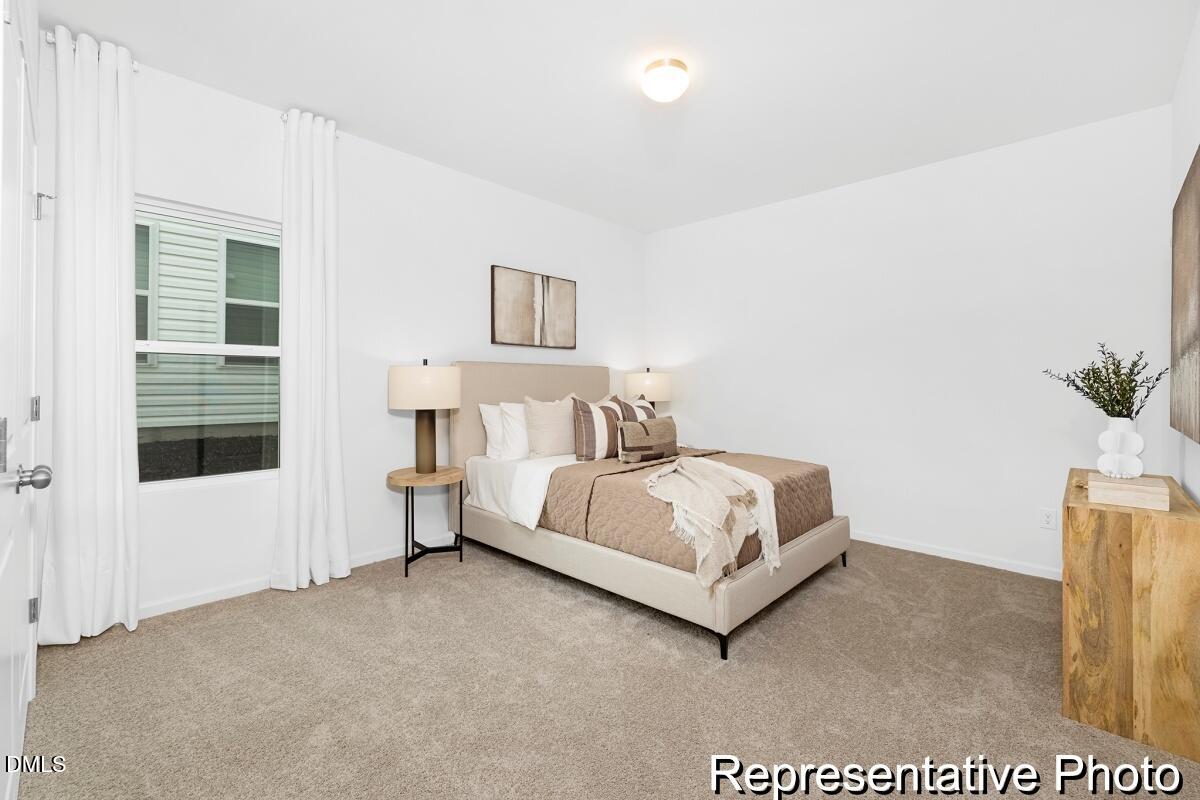 47 Flicker Lane, Unit 188P Angier, NC 27501 - Photo 28 of 38 a bedroom with a bed and a potted plant