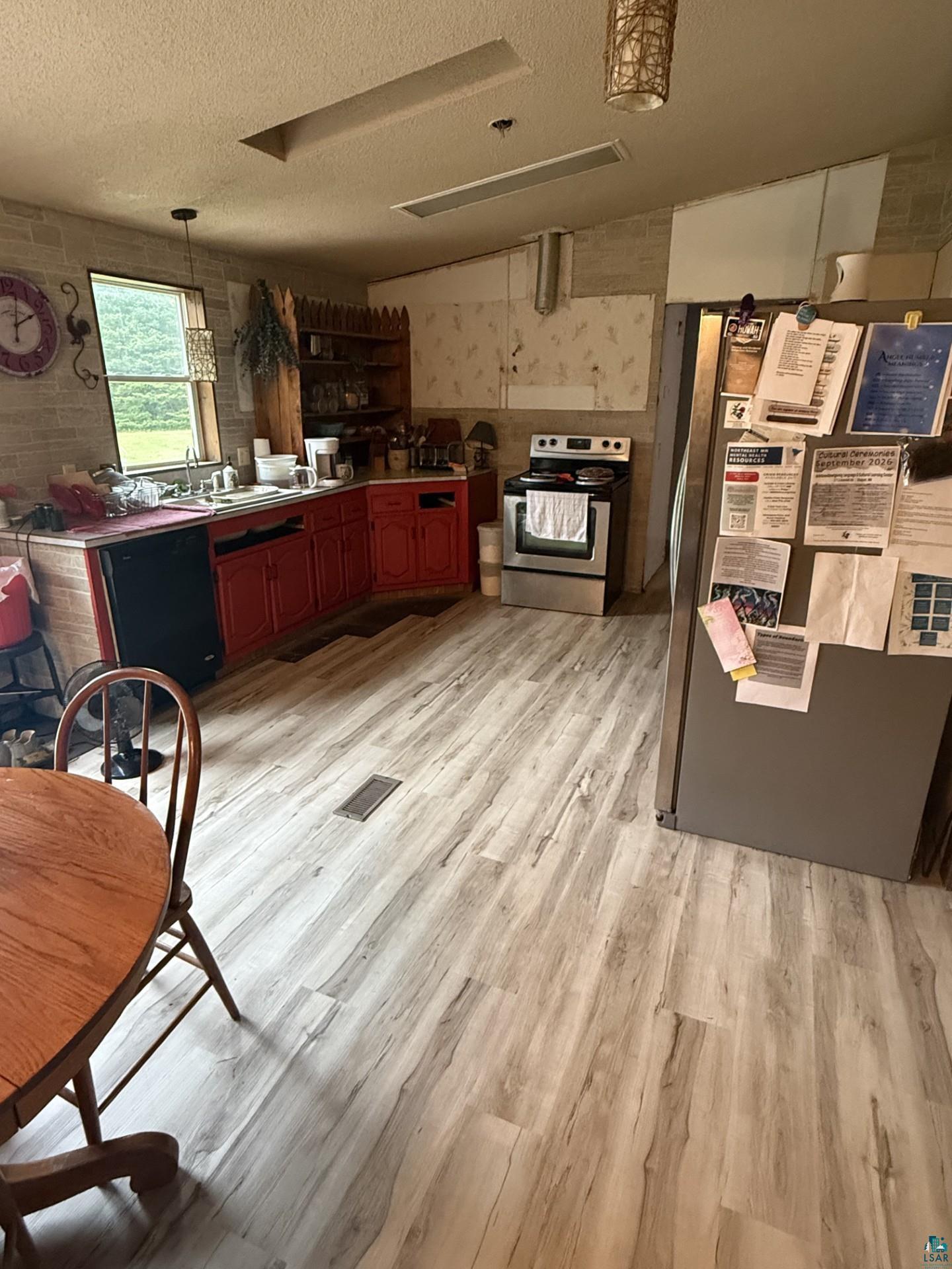 124 Nynas Road Esko, MN 55733 - Photo 4 of 14 Wood-finish flooring throughout, red base cabinets, and a stainless steel range