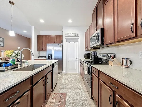 a kitchen with a stove a kitchen island a sink and chairs