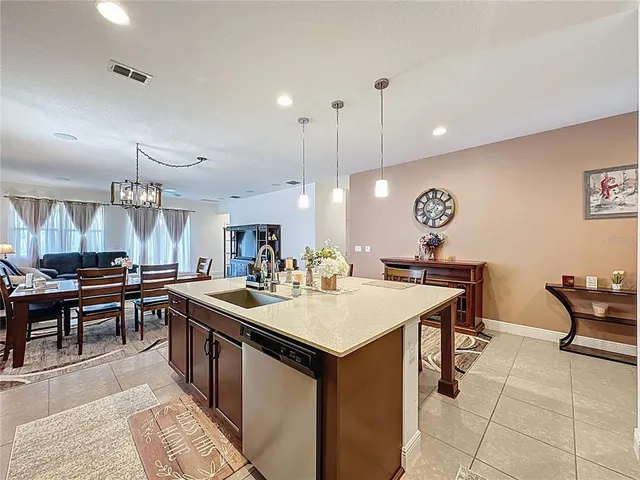 a kitchen with a dining table chairs refrigerator and microwave