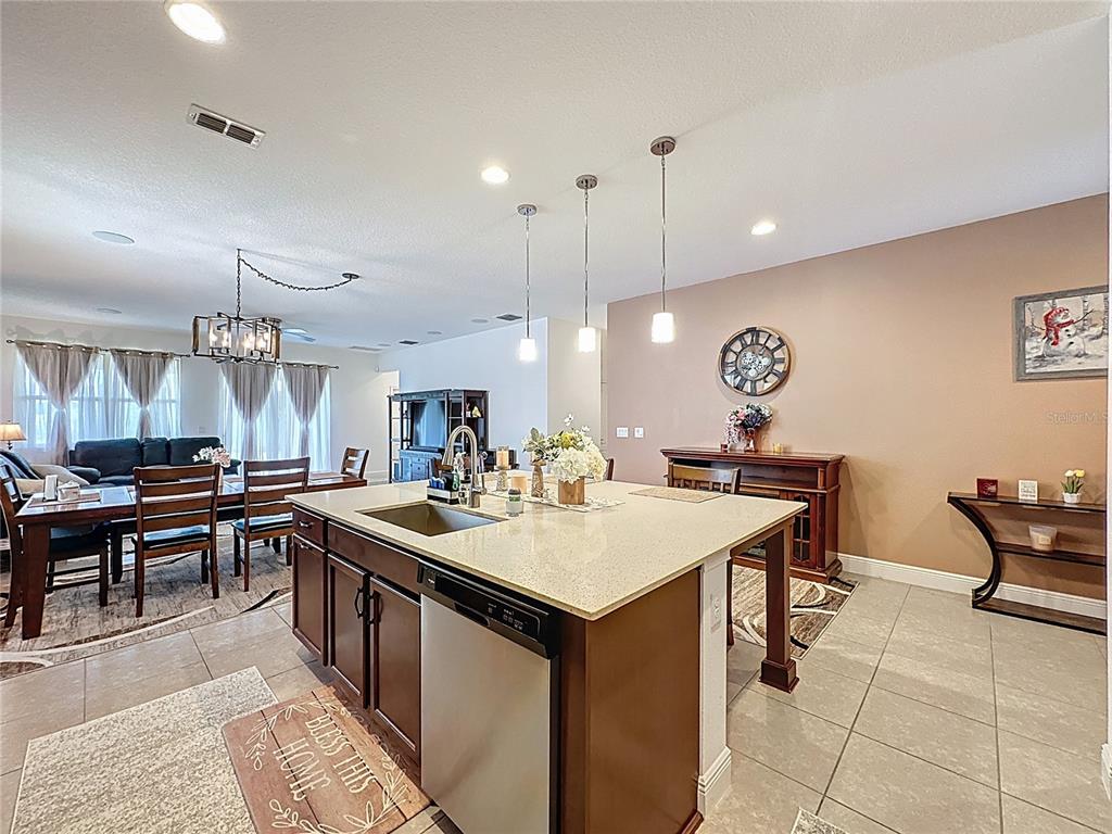3193 Crispin Circle Harmony, FL 34773 - Photo 13 of 64 a kitchen with a stove a kitchen island a sink and chairs