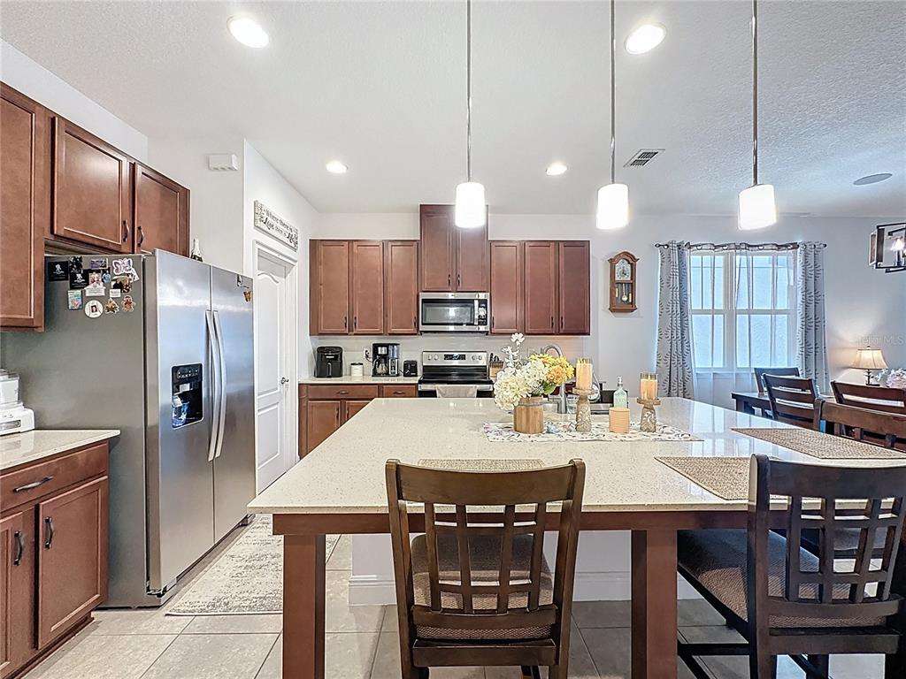 3193 Crispin Circle Harmony, FL 34773 - Photo 14 of 64 a kitchen with a dining table chairs refrigerator and microwave