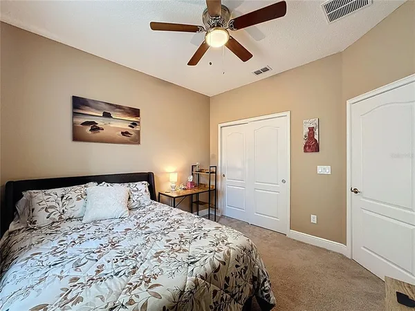 a bedroom with a bed and a flat tv screen on dresser
