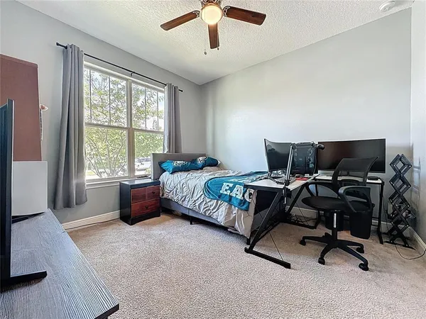 a bedroom with a large bed and a chandelier