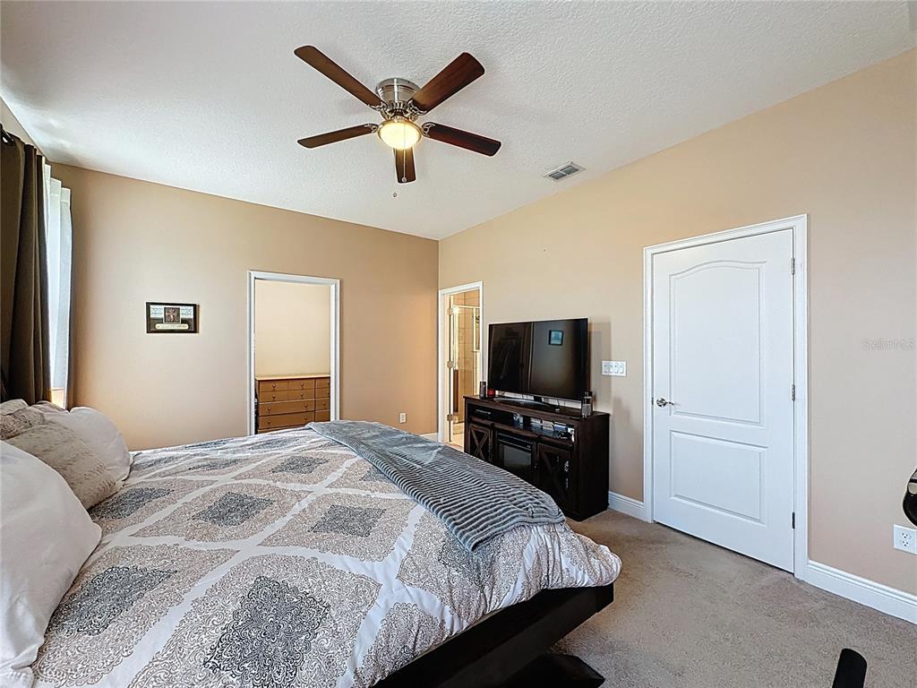 3193 Crispin Circle Harmony, FL 34773 - Photo 26 of 64 a bedroom with a bed and a flat screen tv