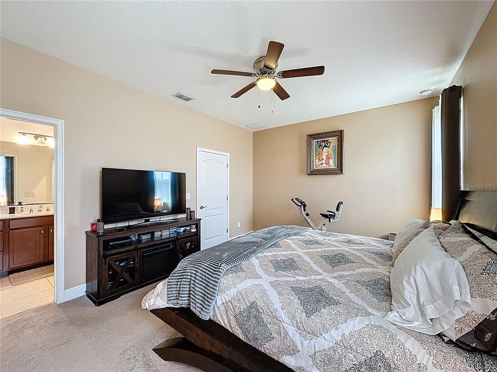 3193 Crispin Circle Harmony, FL 34773 - Photo 28 of 64 a bedroom with a bed and a flat screen tv