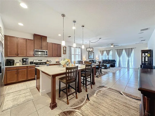 a view of a dining room and livingroom with furniture wooden floor a chandelier