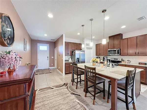 a kitchen with stainless steel appliances a stove a sink a microwave a refrigerator and cabinets