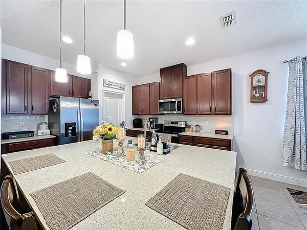 a view of a dining room and livingroom with furniture wooden floor a chandelier