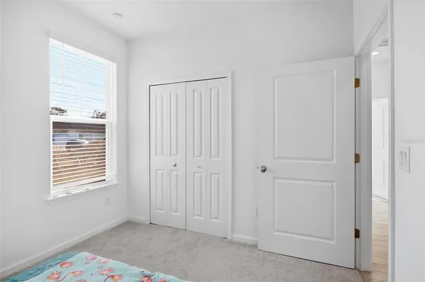 a view of an empty room with closet and a window