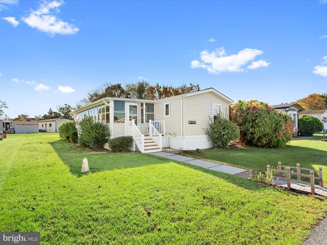 a view of a house with a big yard and a large tree