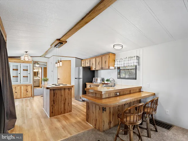 a dining room with kitchen island stainless steel appliances a sink table and chairs