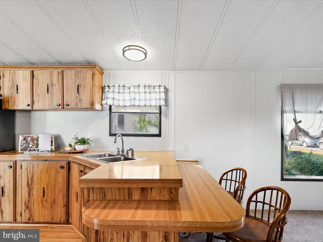 a kitchen with a table chairs sink and cabinets