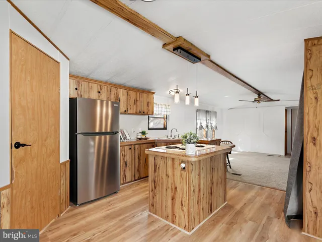 a kitchen with stainless steel appliances granite countertop a stove a refrigerator and a wooden cabinets