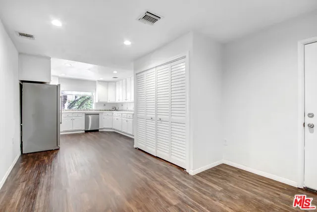 a view of a kitchen with wooden floor and electronic appliances