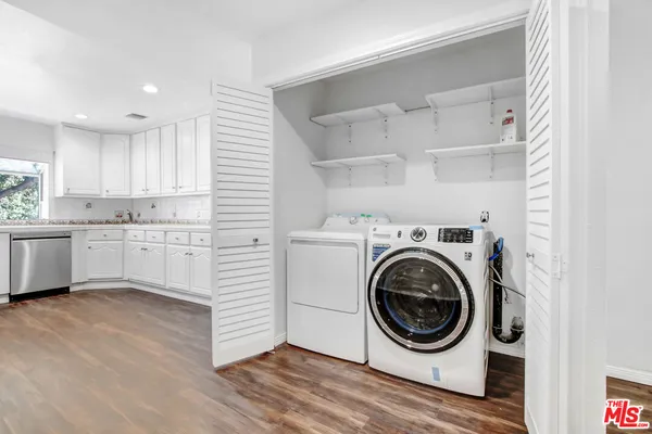 a utility room with cabinets dryer and washer