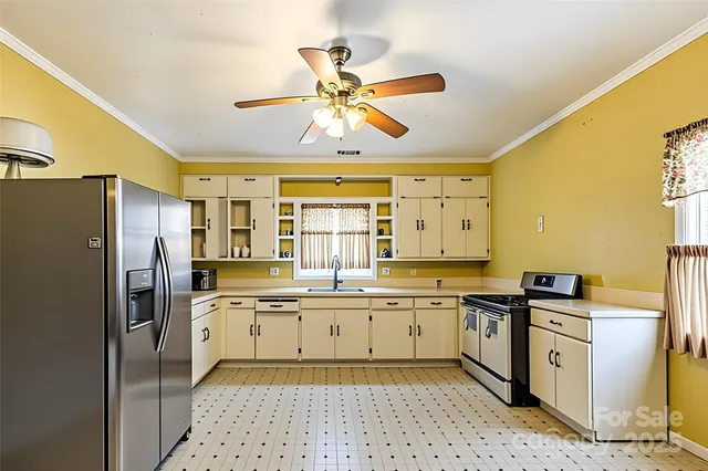 a kitchen with stainless steel appliances a sink a stove a refrigerator and cabinets