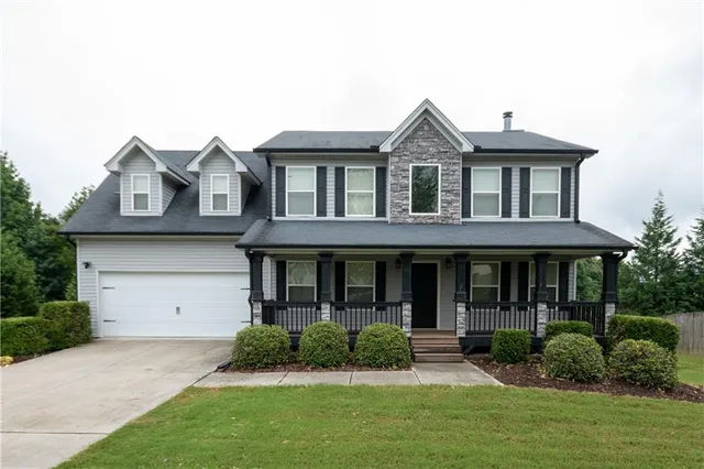 a front view of a house with a yard and potted plants