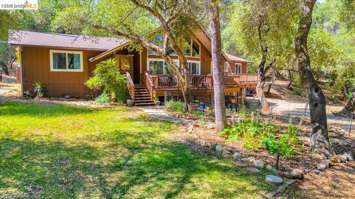 8733 Fraguero Road Sonora, CA 95370 - Photo 9 of 73 Brown-sided exterior featuring a gabled roofline, multi-level decking, and an elevated entrance