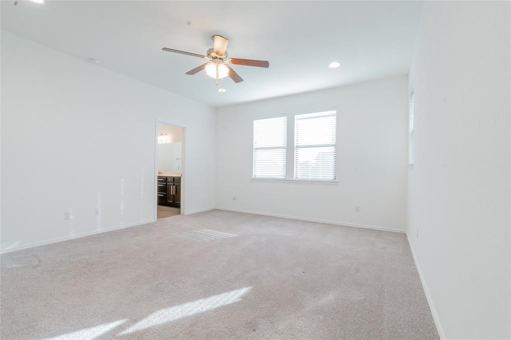 1333 Terrace View Drive Georgetown, TX 78628 - Photo 27 of 35 A spacious primary bedroom features soft carpeting, ample window light, and a convenient ceiling fan.