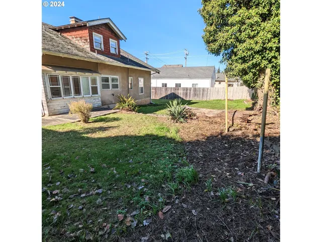 a view of a house with backyard and sitting area