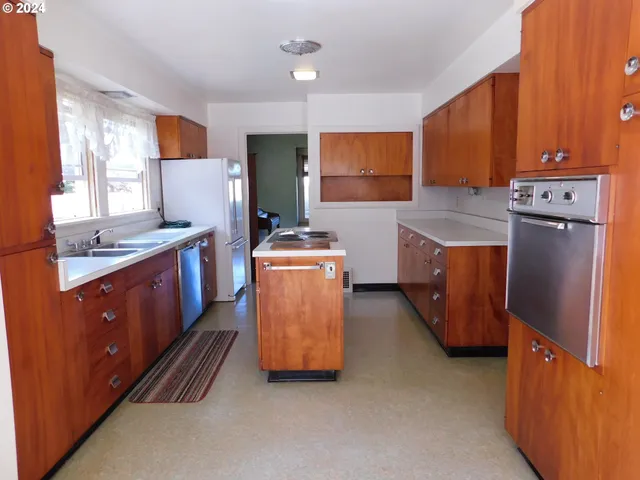 a kitchen with stainless steel appliances granite countertop a stove a refrigerator and a sink