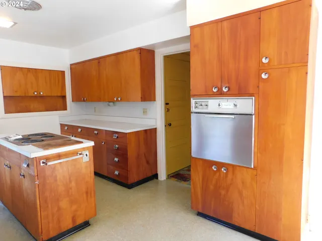 a kitchen with stainless steel appliances kitchen island wooden cabinets a refrigerator and a stove