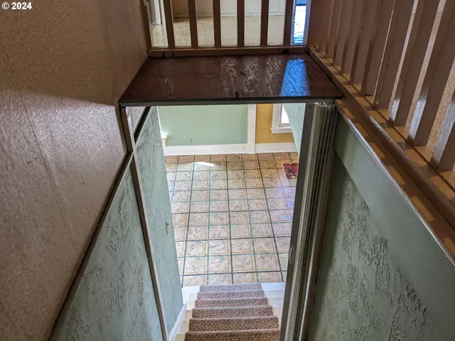 a view of an empty room with a fireplace and a window