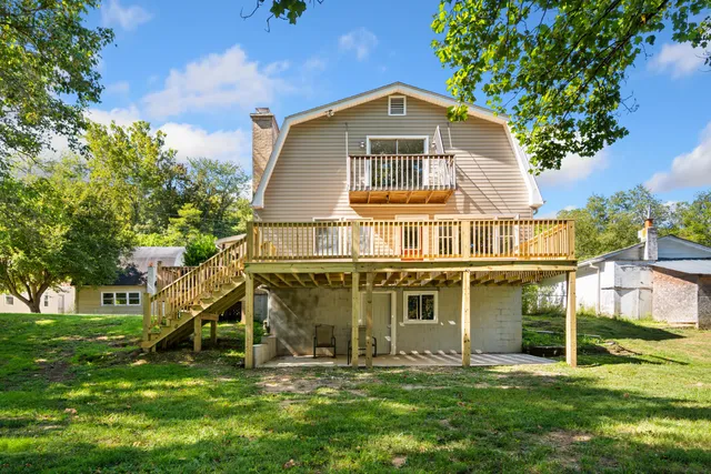 a kitchen with stainless steel appliances a sink a refrigerator a center island and cabinets