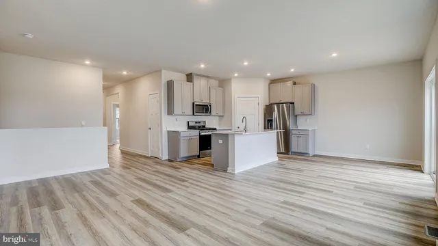 a view of kitchen electric appliances wooden cabinets and wooden floor