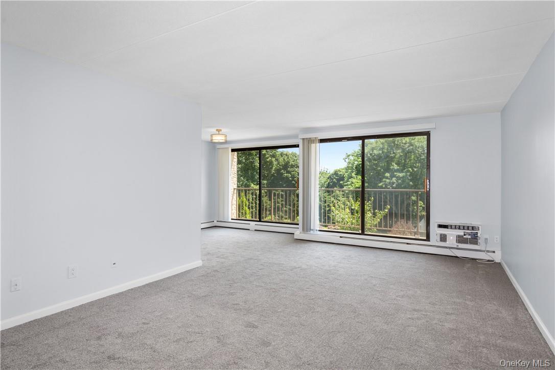 150 Overlook Avenue, Unit 1S Peekskill, NY 10566 - Photo 6 of 23 an empty room with large windows and outdoor space