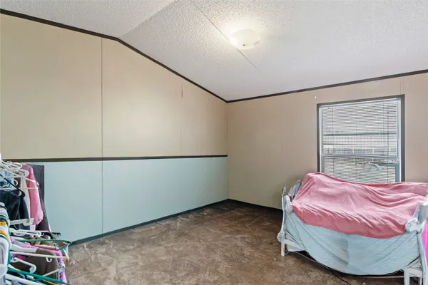 a bedroom with a bed a table and painting on the wall