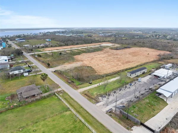 an aerial view of residential houses with outdoor space and ocean view