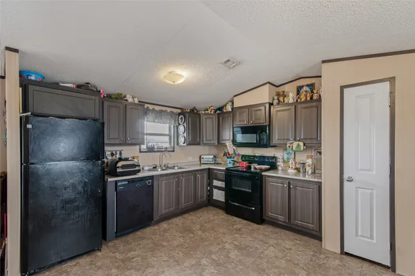 a kitchen with stainless steel appliances kitchen island granite countertop a refrigerator and sink