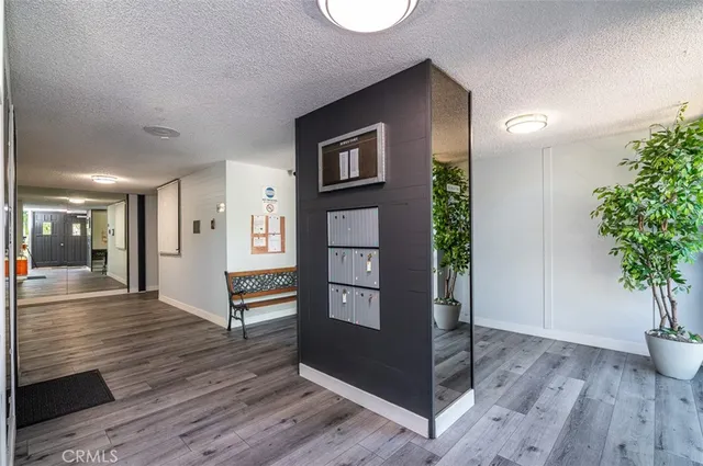 a view of a hallway with wooden floor and a potted plant