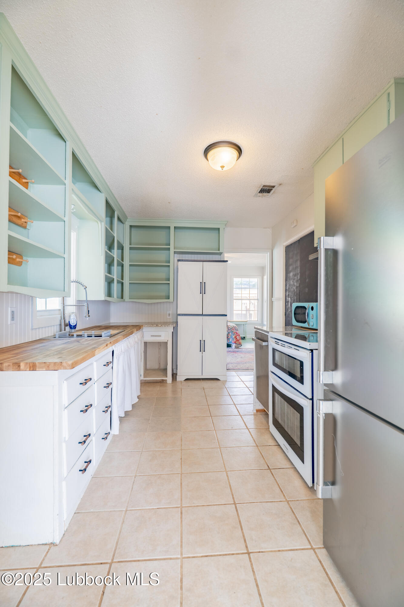 2012 29th Street Lubbock, TX 79411 - Photo 17 of 27 a large kitchen with cabinets and stainless steel appliances