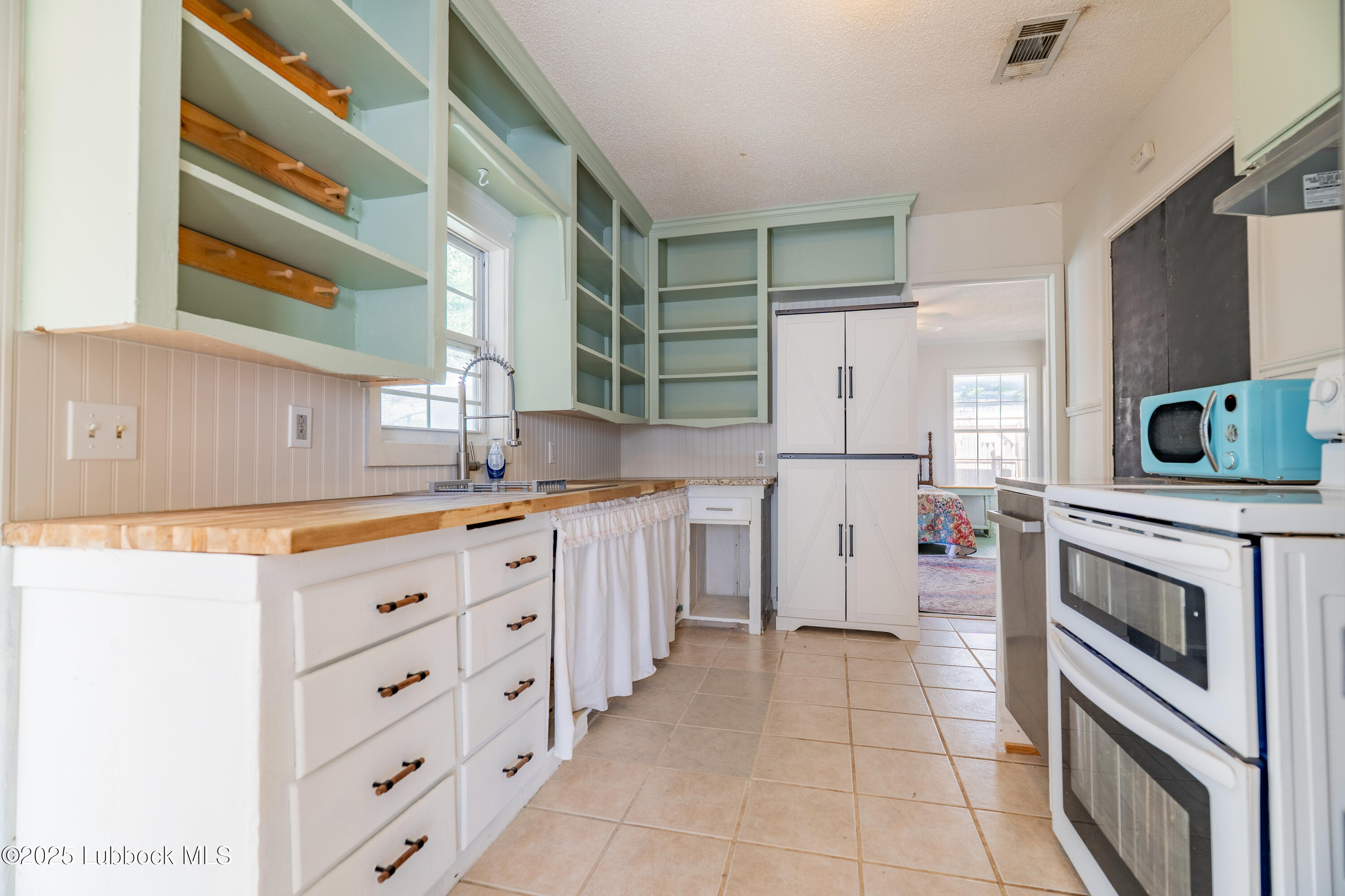 2012 29th Street Lubbock, TX 79411 - Photo 20 of 27 a kitchen with stainless steel appliances a stove sink and microwave