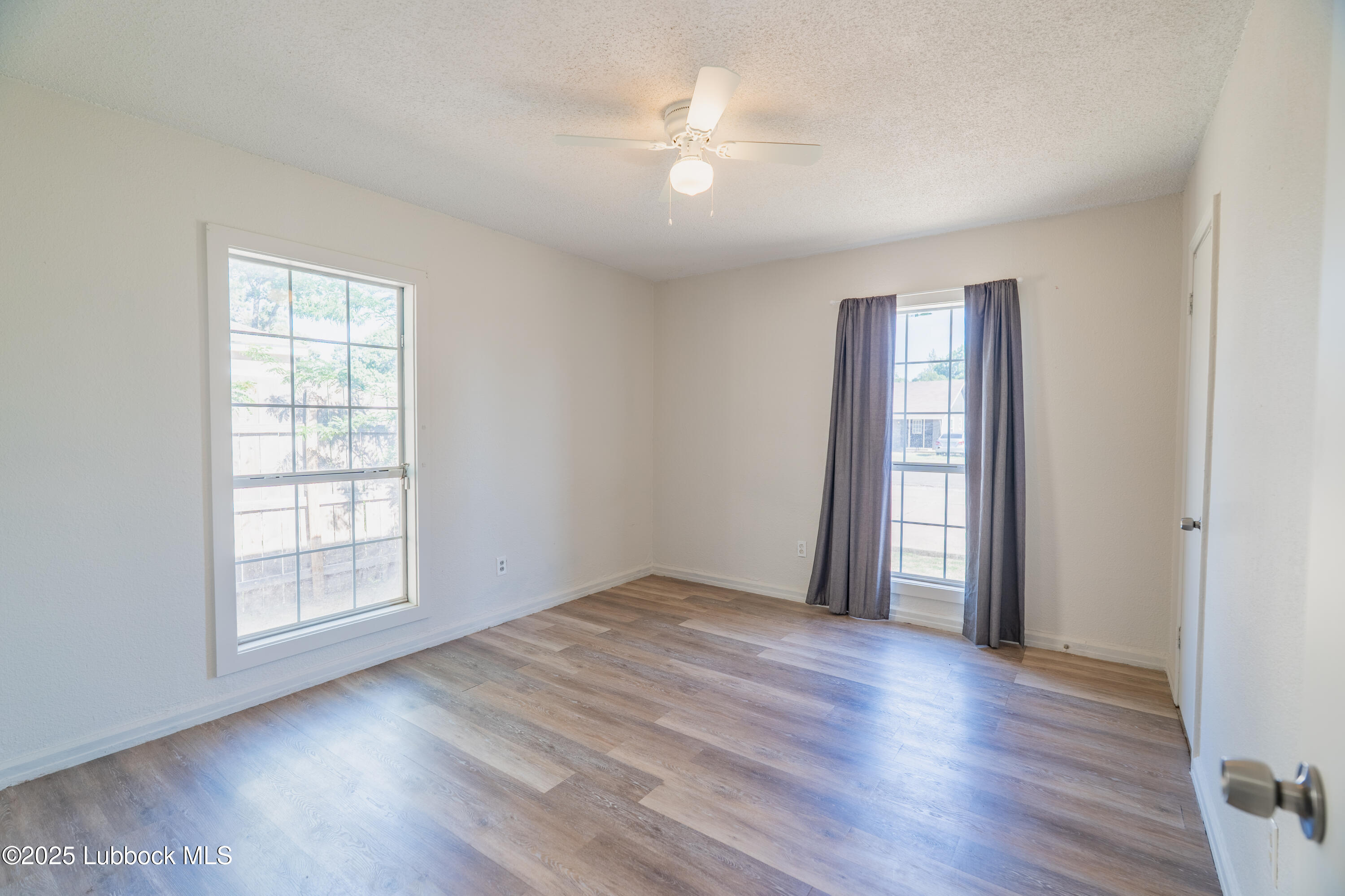 2012 29th Street Lubbock, TX 79411 - Photo 25 of 27 an empty room with wooden floor and windows