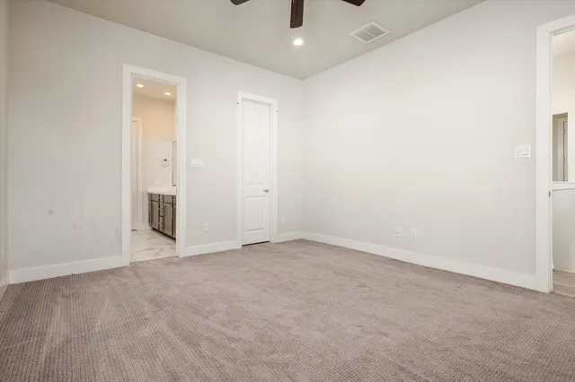 an empty room with chandelier fan