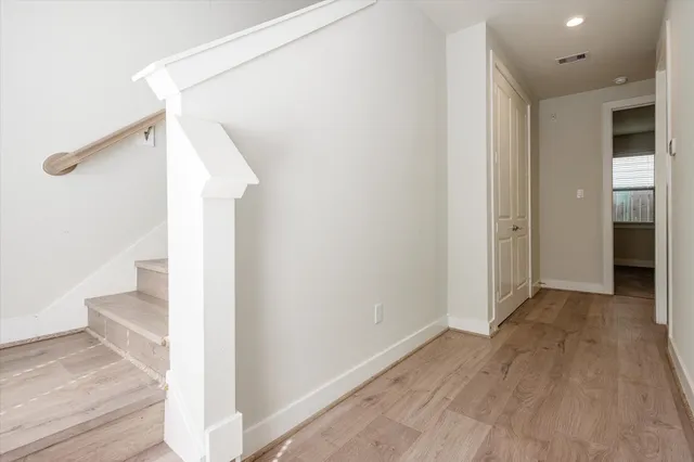 a view of a hallway with wooden floor and staircase