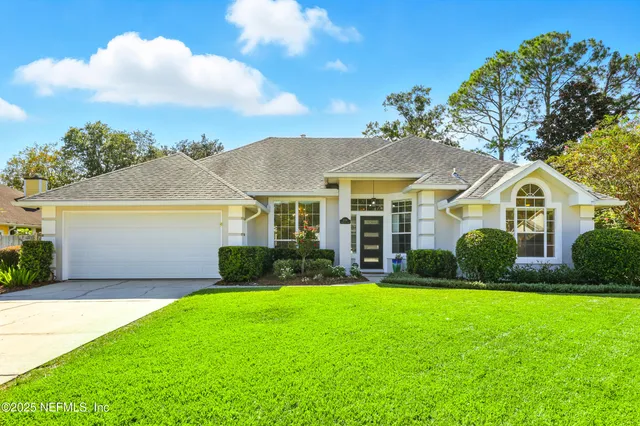 a front view of a house with a garden and yard