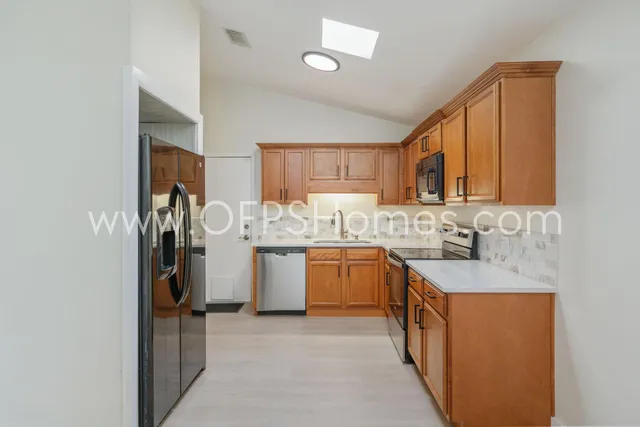 a kitchen with a sink refrigerator and cabinets