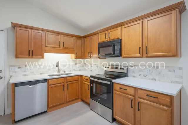a kitchen with stainless steel appliances granite countertop a sink stove and cabinets