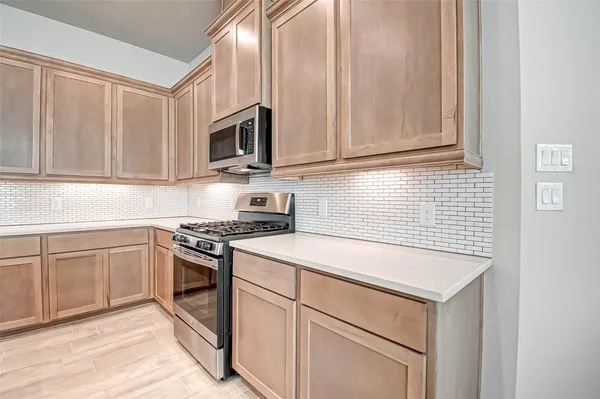 a kitchen with stainless steel appliances granite countertop white cabinets and a stove top oven